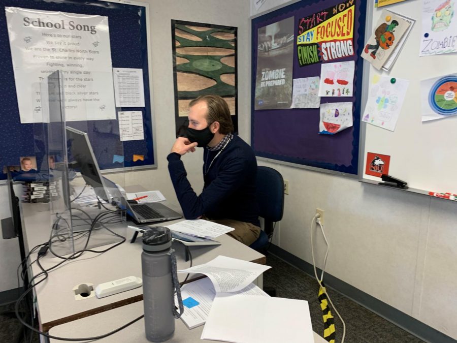 English teacher Scott Von Essen navigates several screens so he can have his lesson pulled up while also being able to see the students at home.