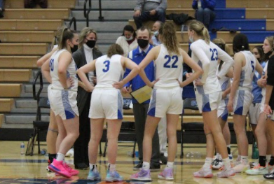 Erin Stack(23) and Katrina Stack(22) talk with their coach during a game.