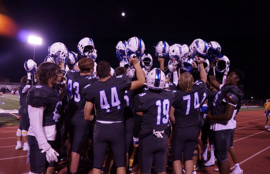 The football team celebrates their win against Wheaton-Warrenville South on Sept. 9.