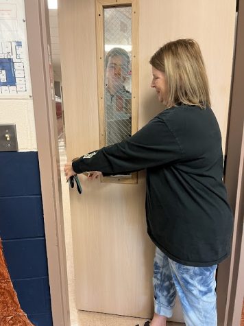 Science teacher Natalie Rosin opens a locked door for junior Tom VanDorpe.