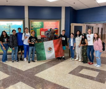 Mi gente poses in front of their decorated display case. 