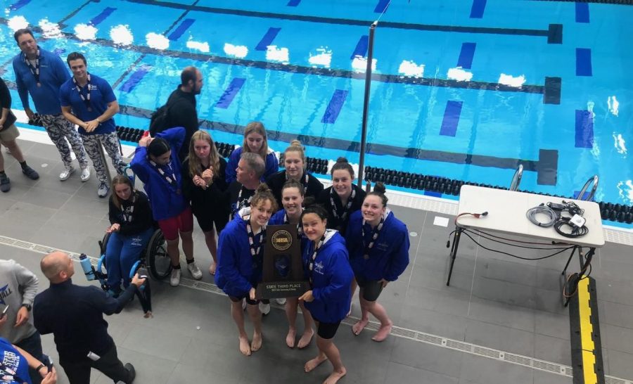 Swimmers+celebrate+with+their+trophy+at+state.+