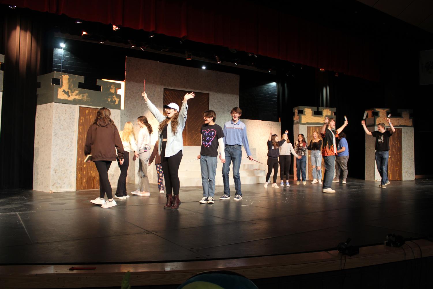 Members of the play rehearse on stage. 