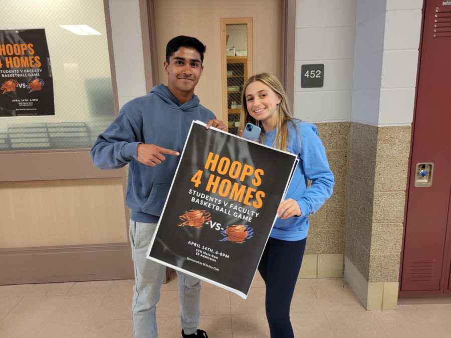 Seniors Natalia Petrucci and Devan Girish holding a Hoops for Homes poster.