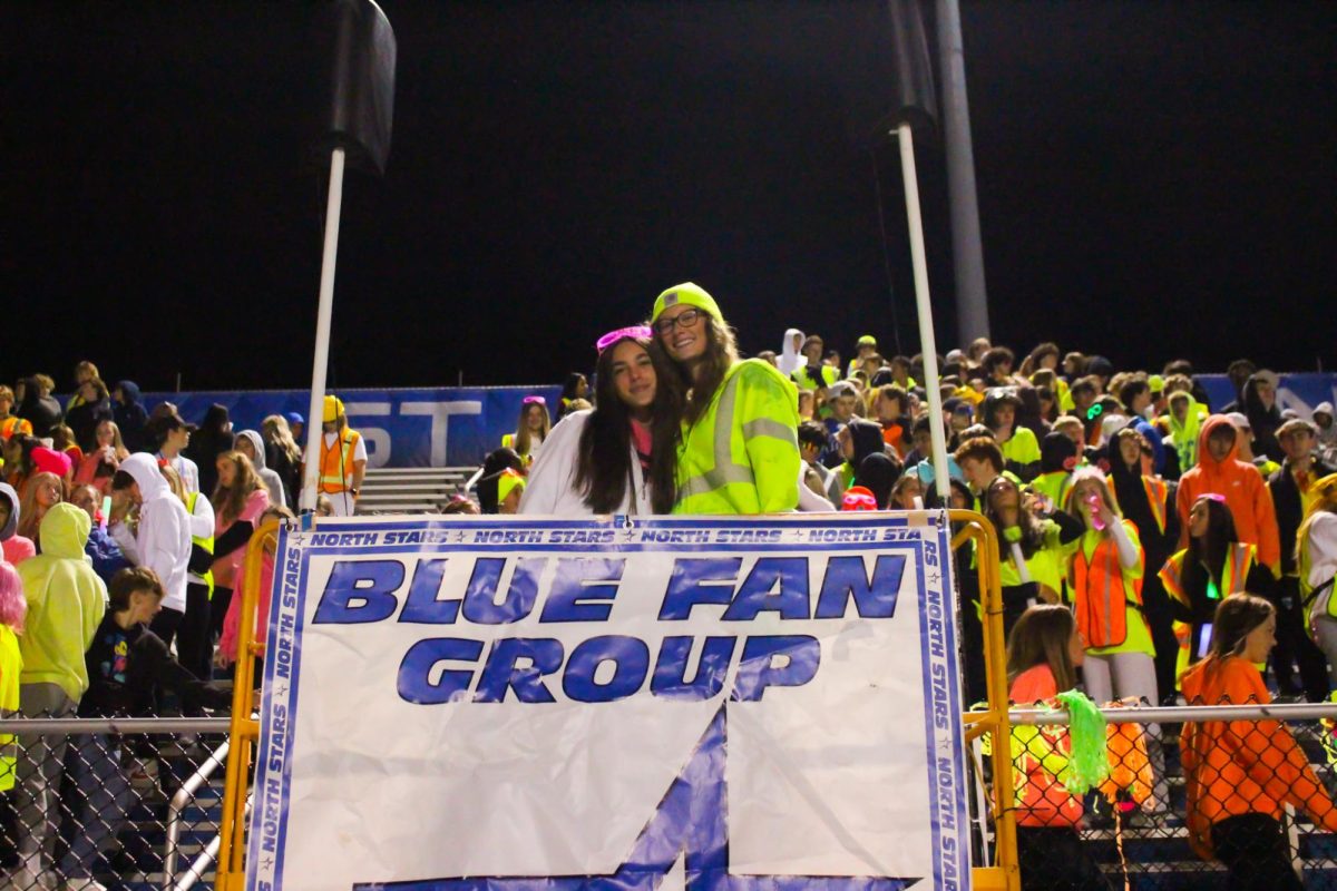 Senior Blue Fan Group members Jordan Bartel and Caitlin Glass on football game scaffolding. 