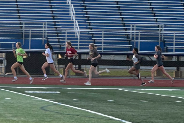 Athletes in girls track and field run during an off-season practice.