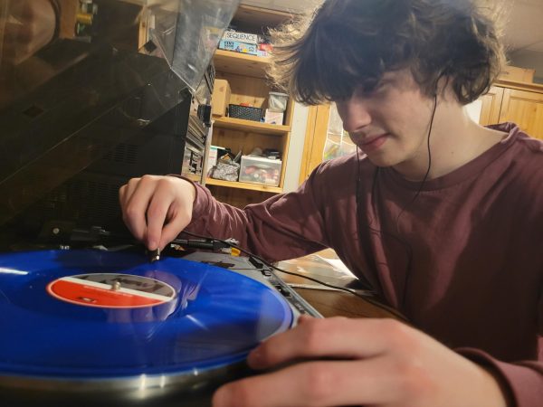 Tyler Moore attempts to use a record player during the Obsolete Tech Test.