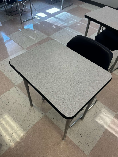 A classroom desk left empty due to a late student.