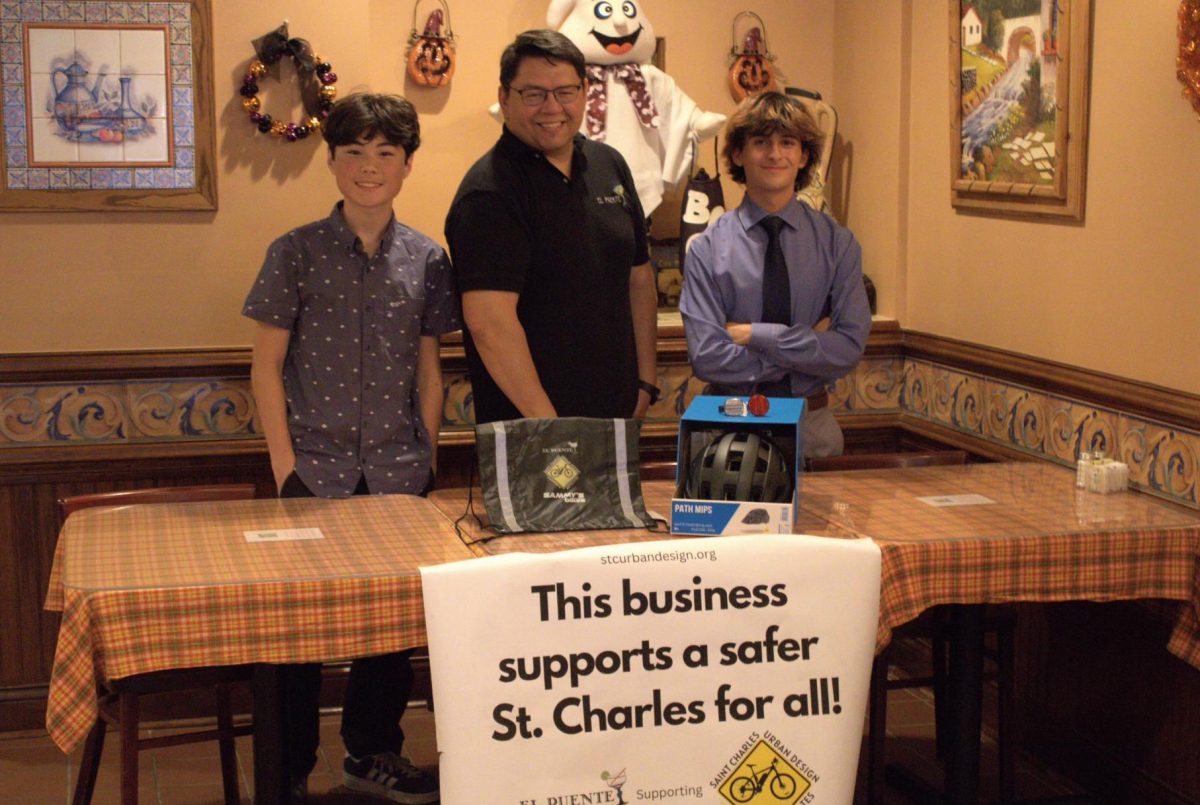 James Bryner and Calvin Reed with El Puente owner David Jimenez and the contents of the biking safety kits.