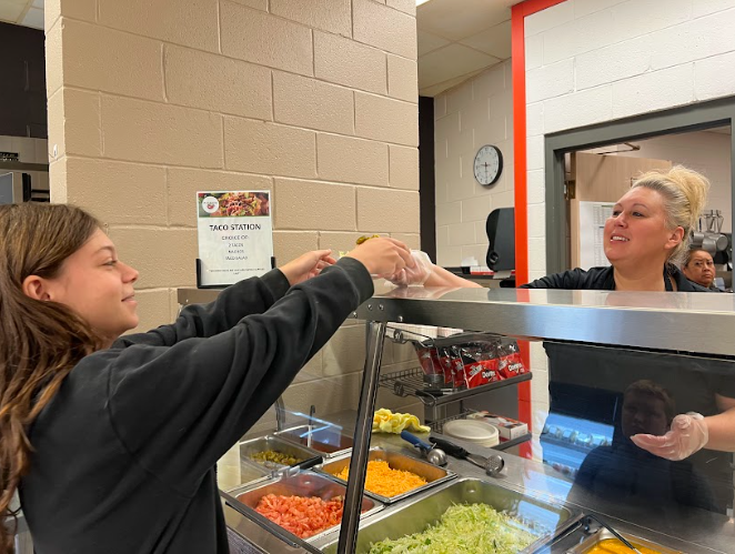 Robin Johnston handing lunch to Ellena Flores, freshman.