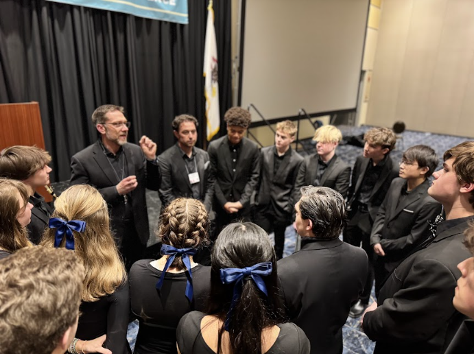 Jazz workshop director John Wojciechowski giving the band a speech before their performance.