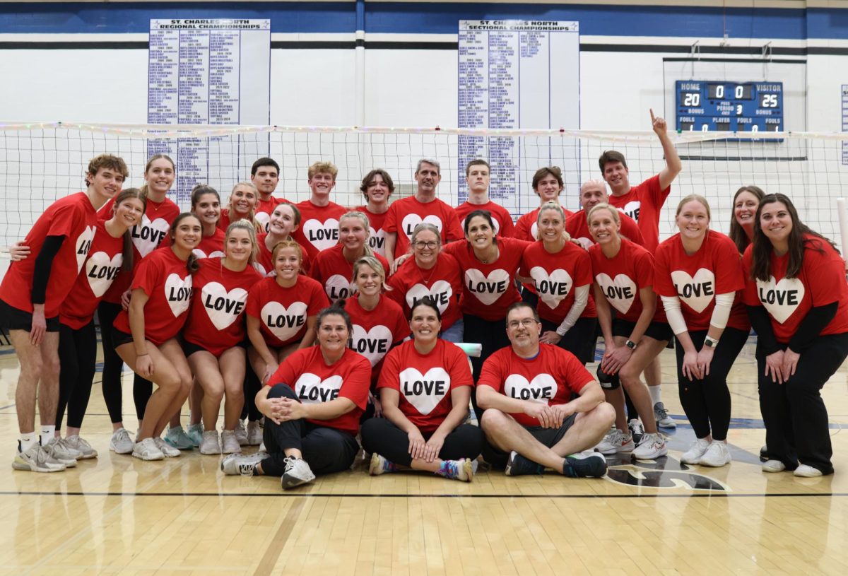 Staff and students smiling at the volleyball game.