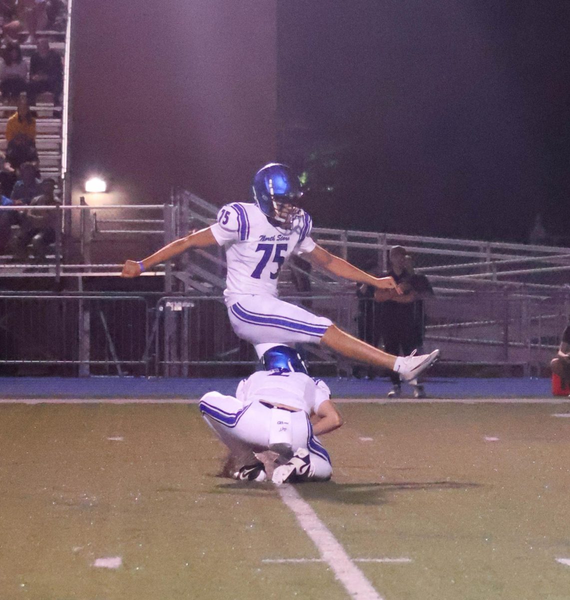 Senior Lucas Tenbrock kicking the ball, set by senior Michael Atkins