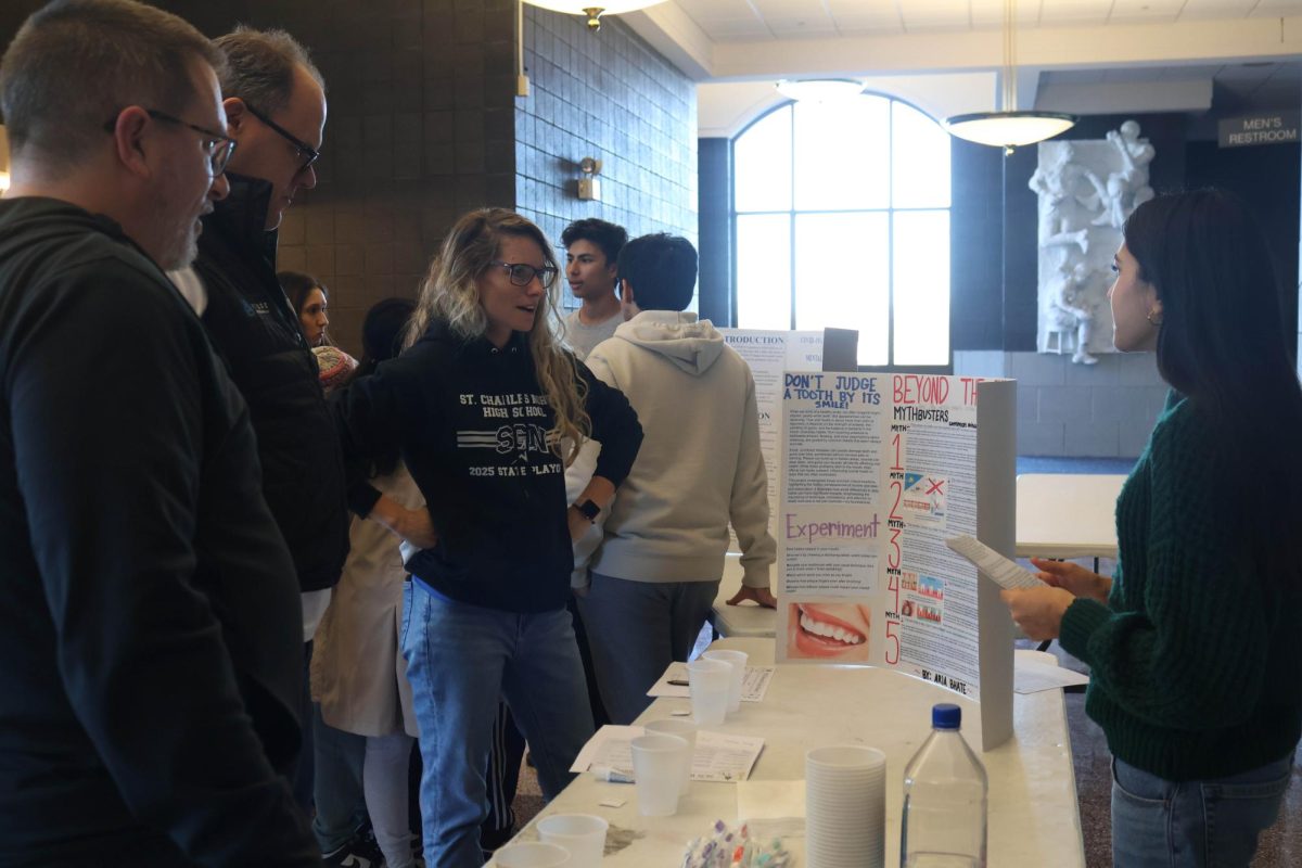 Sophomore Aria Bhate presenting to judges Rebecca LaPorta, Jonathan Mandziara and Peter Gleason