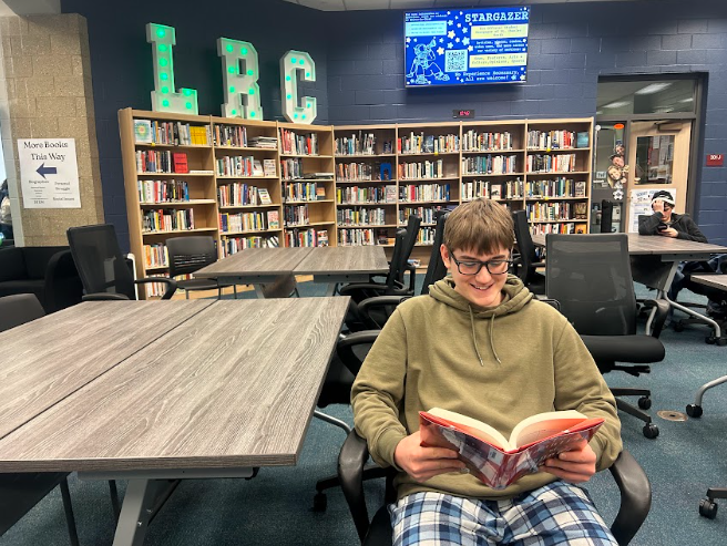 Freshman Ryker Tumminaro reads a book, enjoying the LRC's environment.